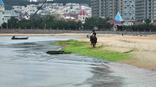 航拍威海市环翠区金海路沙滩上的骑马人