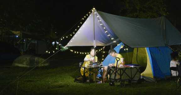 夜晚郊外露营-情侣在帐篷边野炊