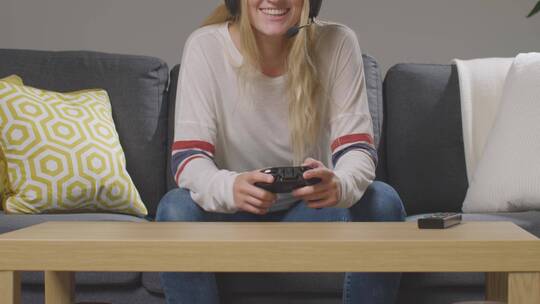 坐在沙发上玩游戏的女人视频素材模板下载