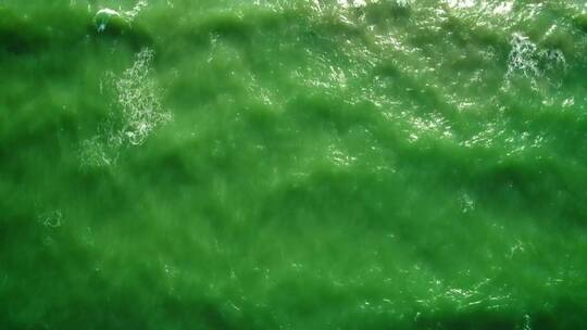 绿色色调的海浪抵达海滩