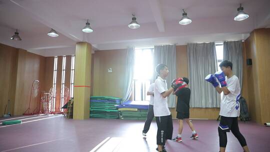 在训练室练习拳击的中学生