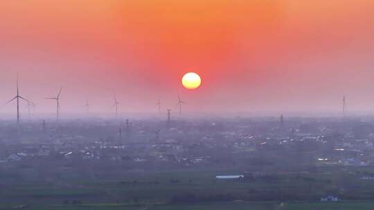 航拍夕阳落日太阳风力发电站群村庄农户平原