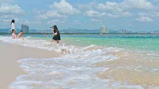 海南三亚蜈支洲岛海岸线白沙滩上大量游客