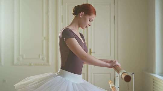 年轻的芭蕾舞演员穿着图图裙伸展练习芭蕾舞