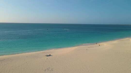 棕榈滩阿鲁巴岛加勒比白色长沙海滩与棕榈树在阿鲁巴岛男人和女人放松
