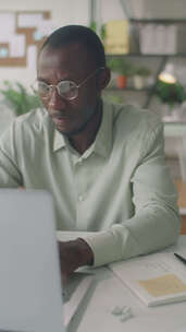 黑人男子在笔记本电脑上打字