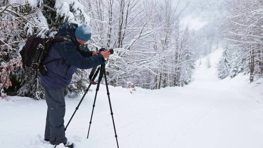 摄影师在森林雪地调试摄影机视频素材模板下载