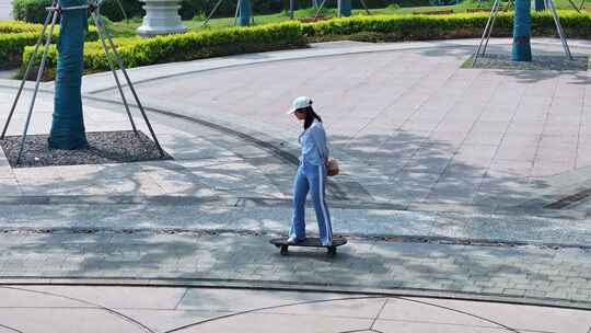 一名年轻美少女在公园广场独自一人练习滑板