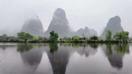 雨天湖景倒映绿树青山的宁静画面