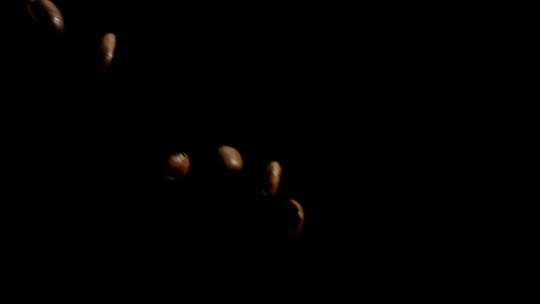 优质咖啡豆从两边缓缓倾泻而下，黑色背景