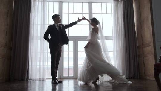 新娘和新郎在落地窗前跳舞