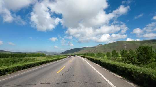 开车行驶在内蒙草原公路上