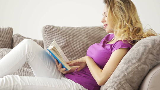 女人躺在沙发上看书