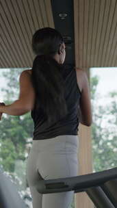 黑人妇女在跑步机上跑步前热身他的背部和臀