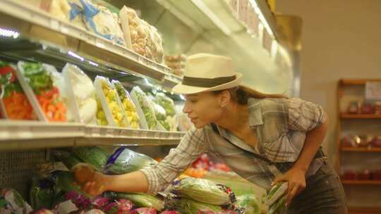 一个女人在食品店看芜菁和胡萝卜