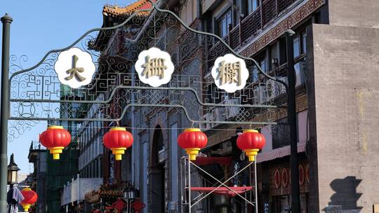 北京前门大栅栏新年里工作人员正在挂灯笼