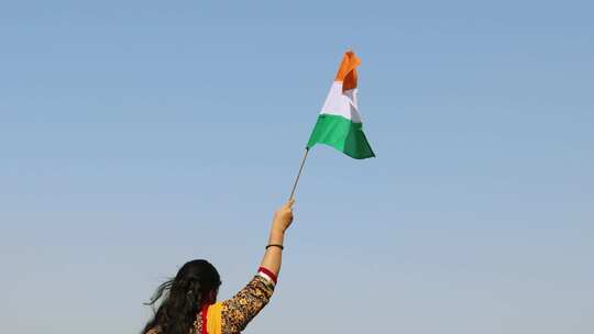 年轻的印度女孩手持印度三色国旗，白天挥舞视频素材模板下载