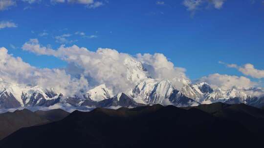 蓝天白云下的雪山全景