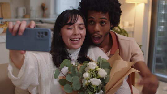 幸福的配偶用一束白玫瑰在智能手机上拍照
