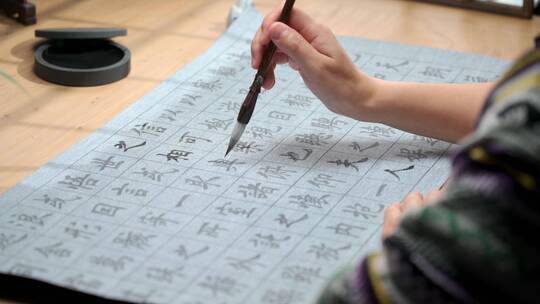 用字帖练习毛笔字的亚裔女性视频素材模板下载