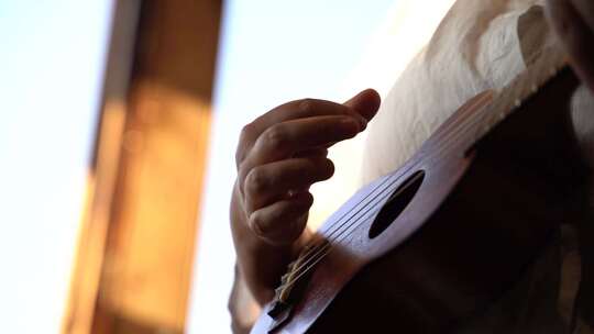 手部特写弹奏尤克里里的画面