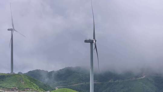 绿色山丘上的风力发电机群全景