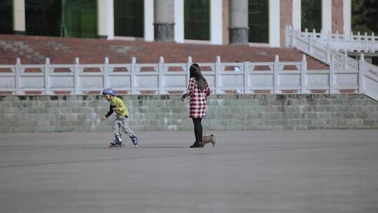 广场上溜冰的少年牵小狗的小姐姐