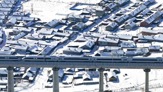 中国黑龙江高铁列车冬季行驶在雪乡村落