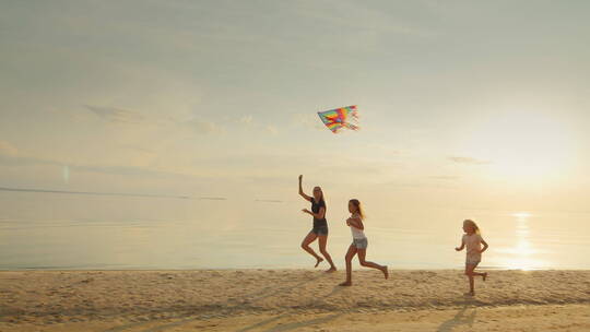 妈妈和两个女儿在海滩上玩风筝