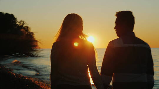 日落时夫妇在海滩上散步