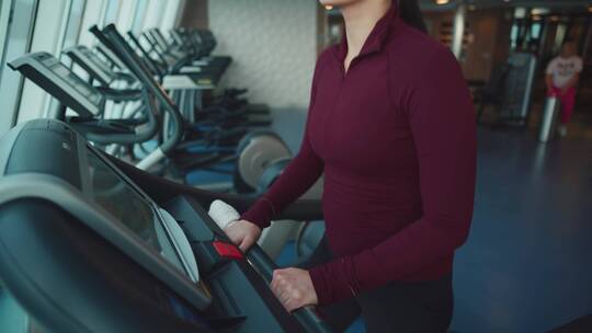女人在健身房跑步机上奔跑健身 