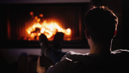 男人坐在壁炉前视频素材模板下载