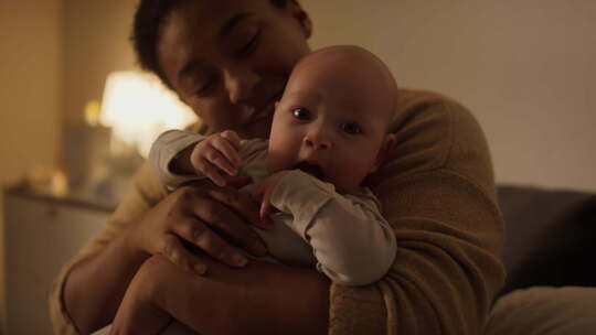 微笑的聚乙烯女人抱着婴儿咀嚼手指视频素材模板下载