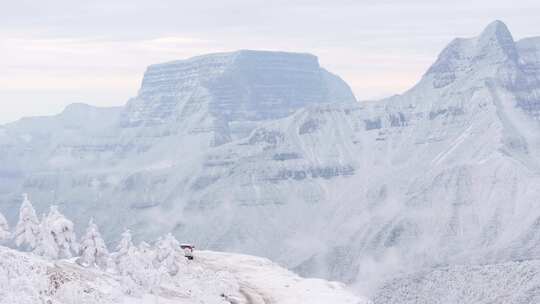 航拍男人站在大雪后的大瓦山前