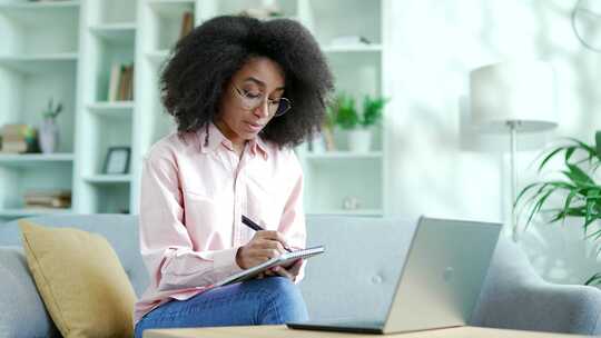 年轻的非裔美国女学生使用笔记本电脑收听在
