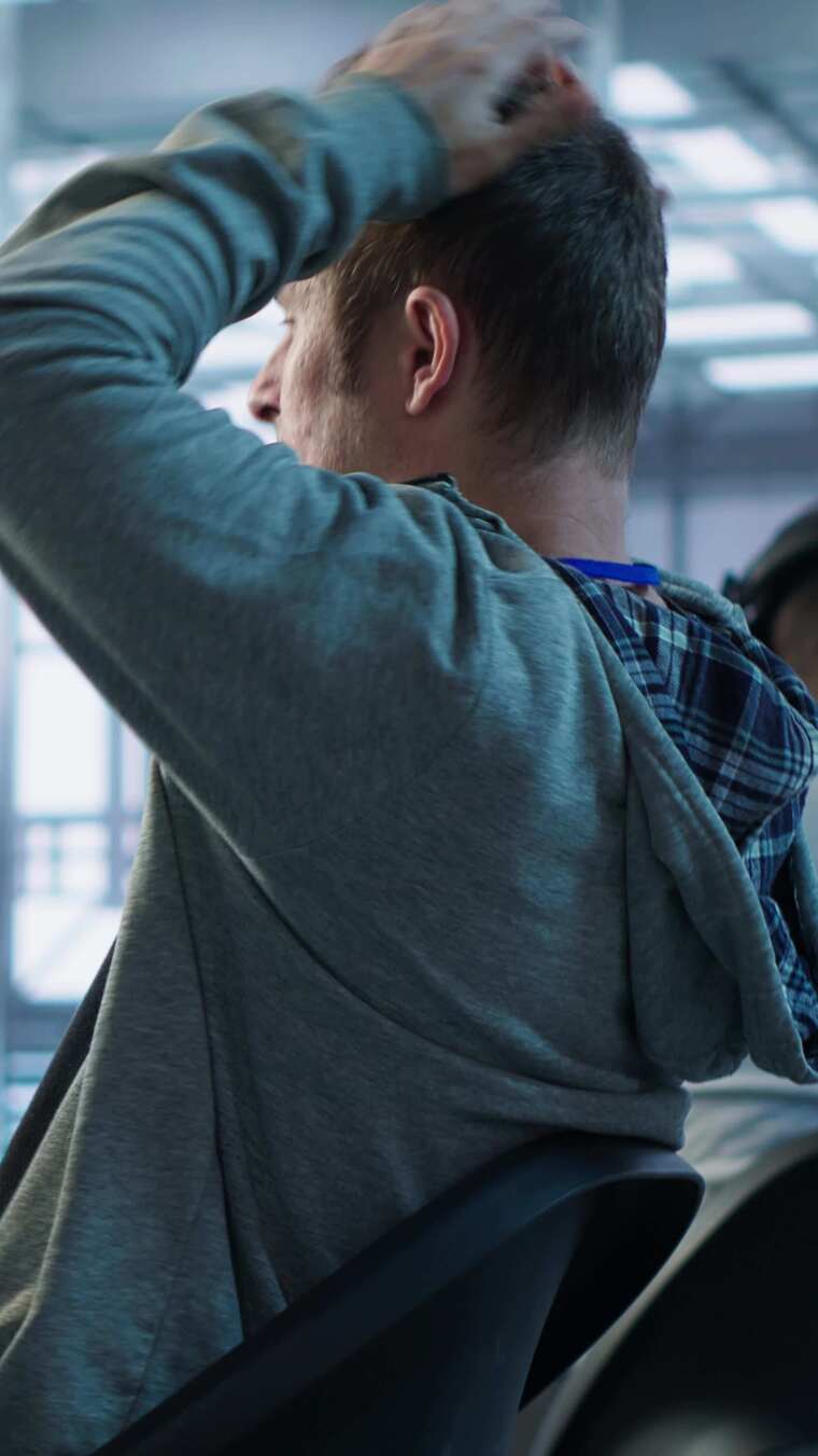 疲劳的管理员在服务器机房工作时伸展身体以