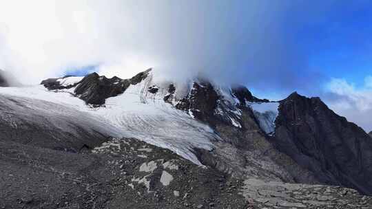 航拍四川甘孜云雾缭绕的乌库楚雪山风光