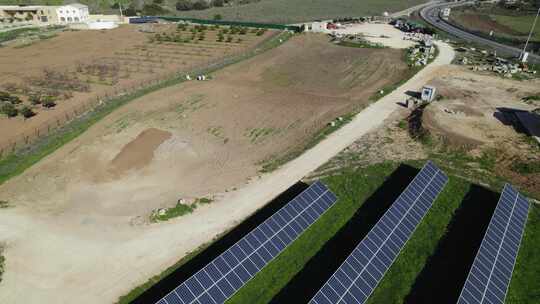 无人机回撤显示葡萄牙农村道路旁边的太阳能电池板