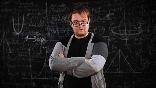 年轻成年教授或科学家的肖像，背景黑板上覆盖着粉笔配方视频素材模板下载