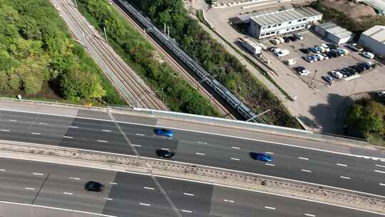 英国鸟瞰高速公路下的通勤列车超速行驶