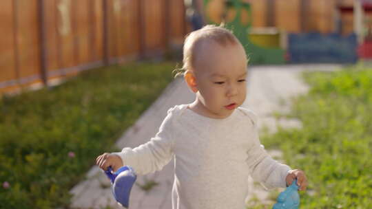 孩子在花园里带着玩具走路视频素材模板下载