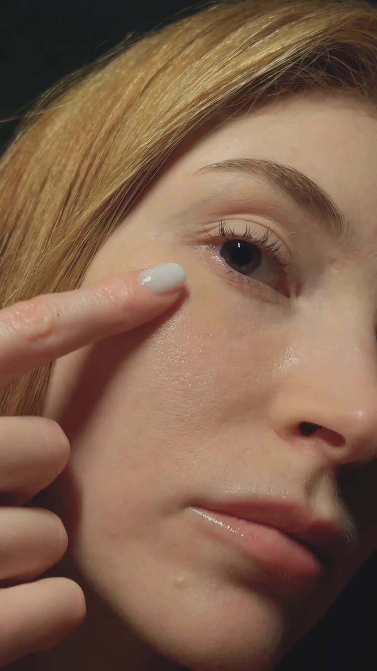 一个女人在她眼睛下面敲打的特写镜头