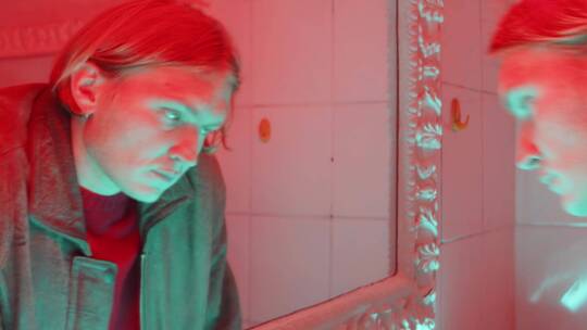 男人在红色灯光的浴室里洗脸