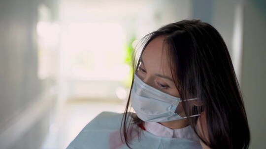 女医生摘下她的医用口罩并微笑