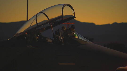 战斗机飞行员黄昏时在跑道上准备喷气式飞机