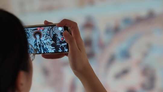 游客用手机在敦煌莫高窟洞窟内拍摄