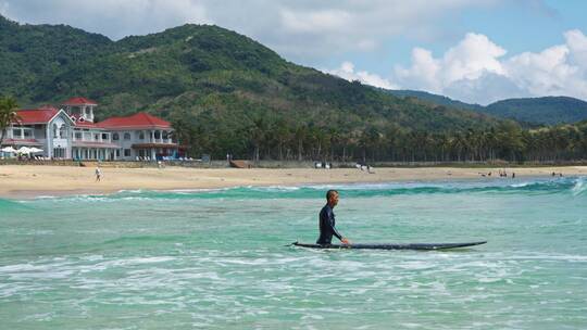男人推着冲浪板走向大海万宁海滩冲浪慢镜头