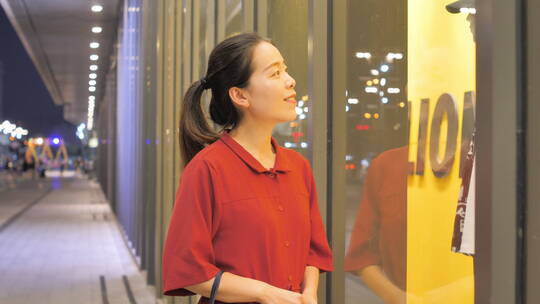 亚洲东方中国女性在商场看橱窗衣服