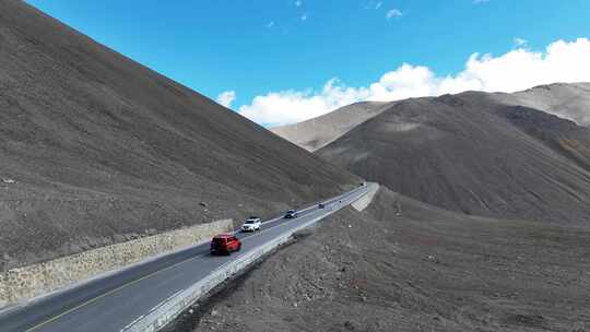 一辆红色越野车行驶在西藏的户外道路上