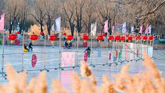 北京冬季阳光下朝阳公园冰场滑冰的人群